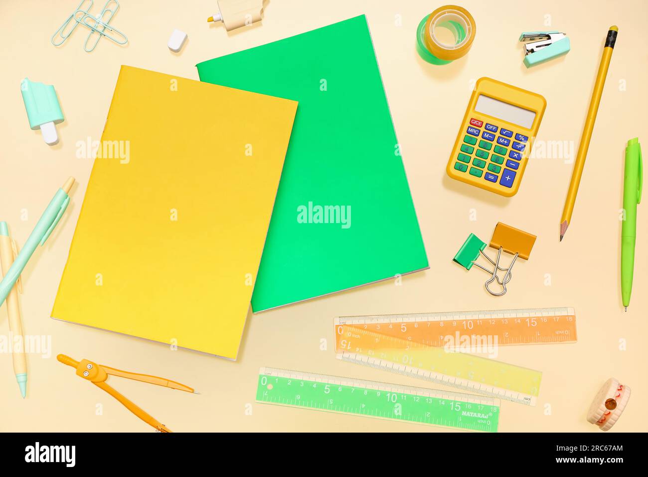 Notebooks with different stationery on pale yellow background Stock Photo