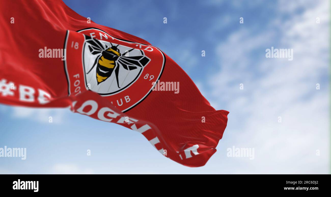London, UK, Feb 19 2023: Brentford Football Club flag waving in the wind on a clear day. Circular emblem with a bee inside on red. Illustrative editor Stock Photo