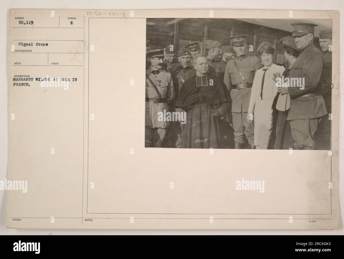 Margaret Wilson, daughter of President Woodrow Wilson, is seen at the YMCA in France during World War I. The photograph, taken by a Signal Corps photographer, is numbered 50,119. It was issued as a symbol B and is described as depicting Margaret Wilson at the YMCA in France. Additional notes include the numbers 50119 and 3-108. Stock Photo