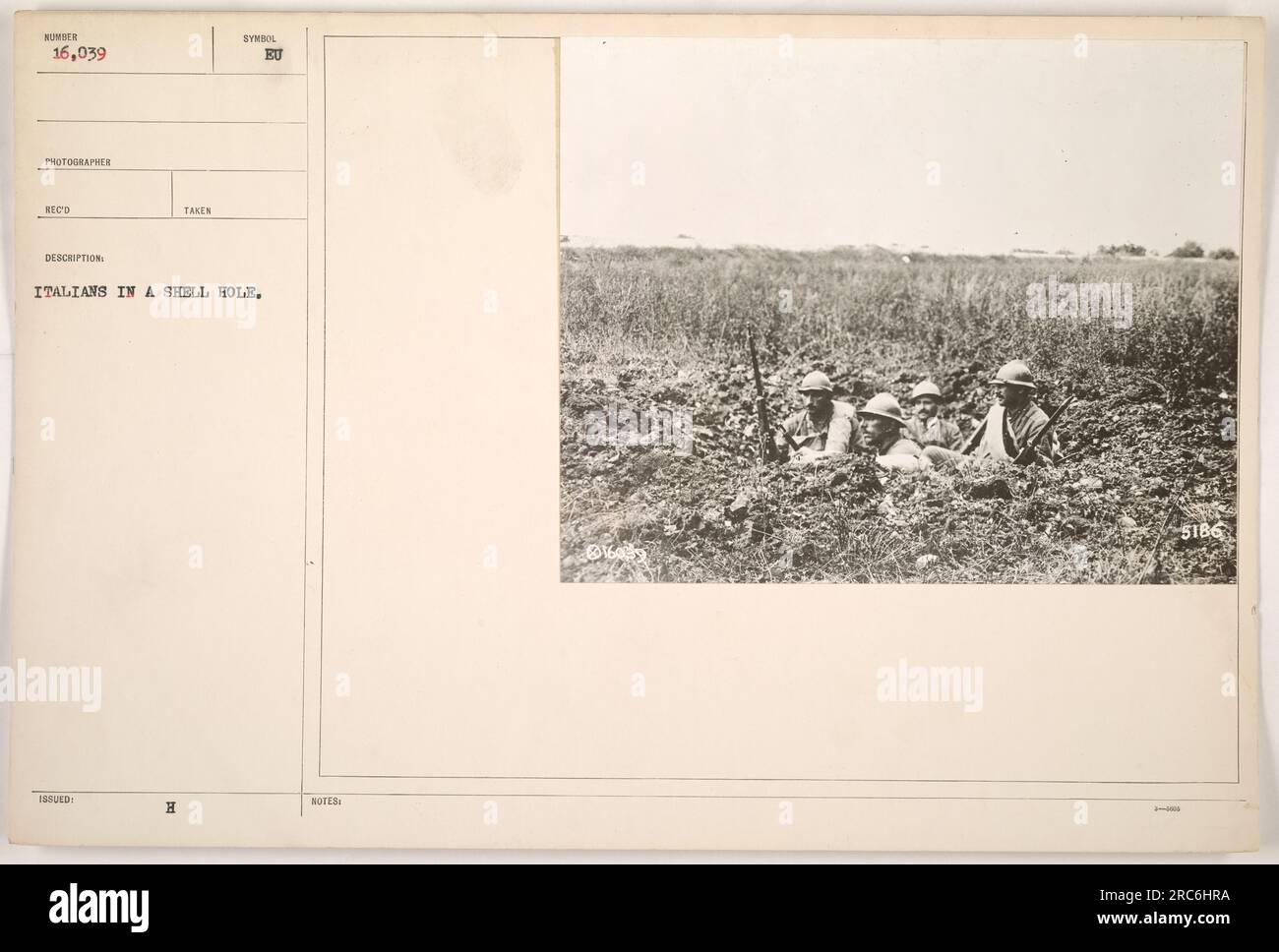 This photograph, numbered 16,039 in the collection, is a black and white image taken by an American photographer during World War One. It shows a group of Italian soldiers huddled in a shell hole. The photo bears the symbol 'H' and the notes indicate that it was captured in Italy. Stock Photo