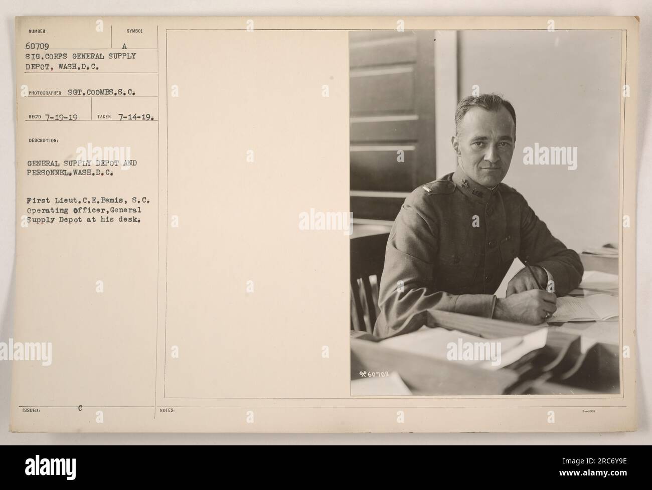 First Lieut. C.E. Bemis, S.C., the operating officer at the General Supply Depot in Washington D.C., is pictured sitting at his desk. This photograph was taken on July 14, 1919, by photographer Sot. Coombs. The image is part of a collection documenting American military activities during World War One. Stock Photo