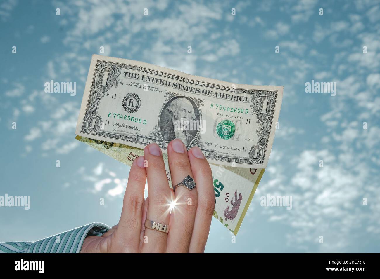 Woman holding a dollar bill and 500 argentine pesos. Economy of Argentina. Concept Of Inflation And Rise Of The Dollar In Argentina Stock Photo