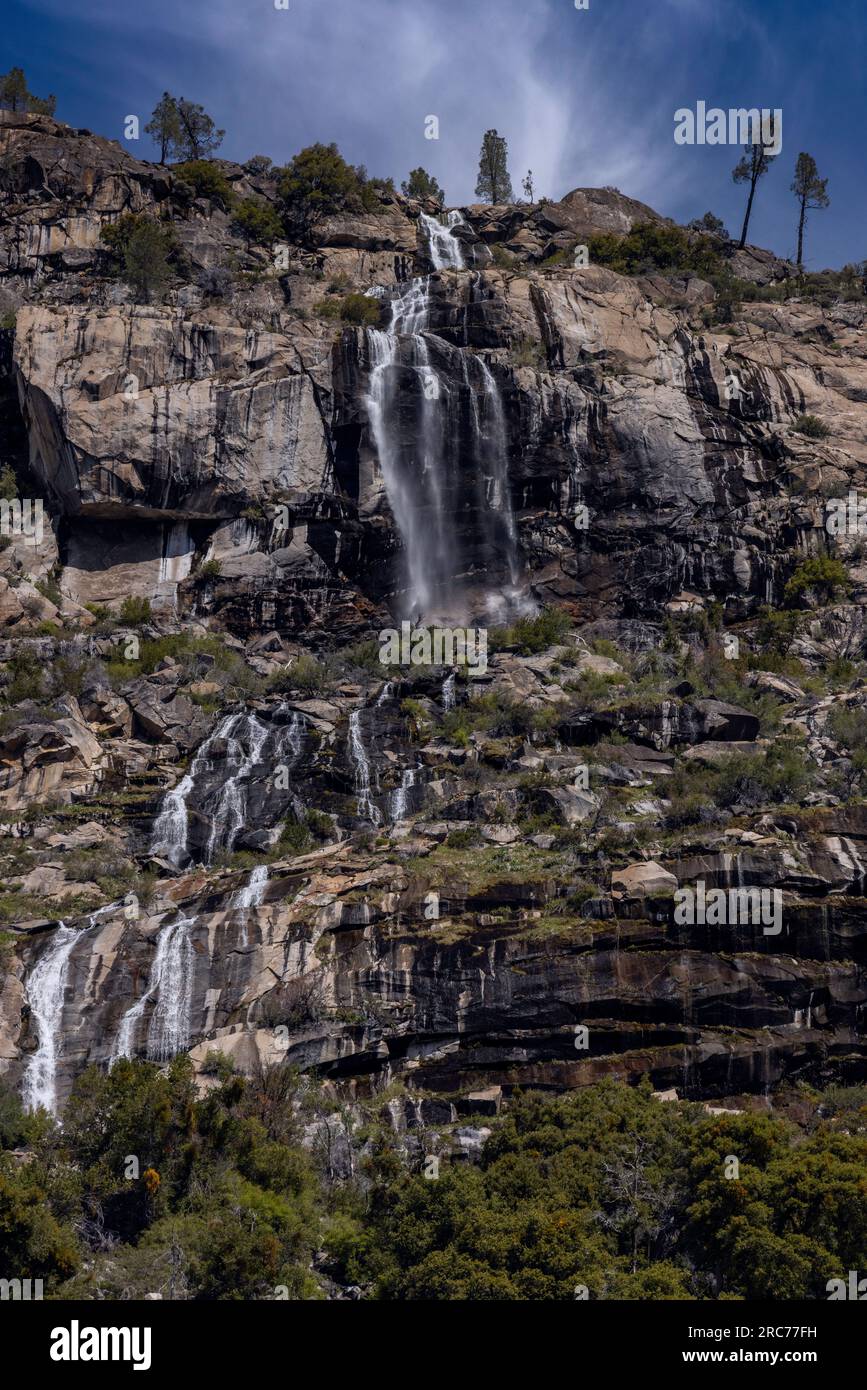 A spring run off waterfall falling down rocky cliffs along the Wapama Waterfall Trail in Yosemite National Park. Stock Photo
