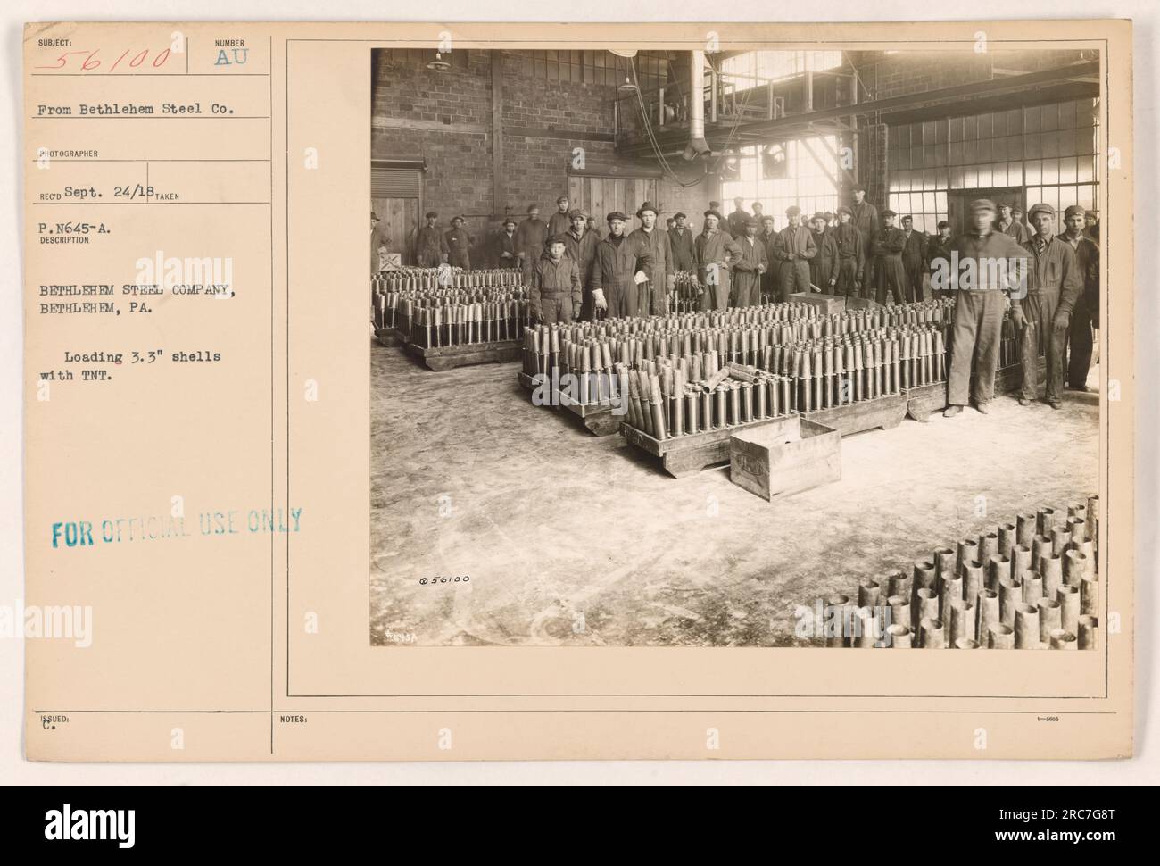Caption: Workers at Bethlehem Steel Company in Bethlehem, PA, load 3.3" shells with TNT during World War I. This photograph, taken by photographer RECO on September 24, 1918, focuses on the crucial production of artillery ammunition. The image is marked as "FOR OFFICIAL USE ONLY WUED NOTES." Stock Photo