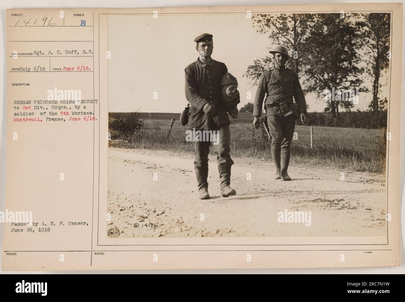 A German prisoner being escorted by a soldier of the 5th Marines to the 2nd Division headquarters in Montreuil, France on June 6, 1918. This photograph, taken by Sgt. A. C. Duff, shows the capture and transportation of enemy prisoners during World War One. Stock Photo
