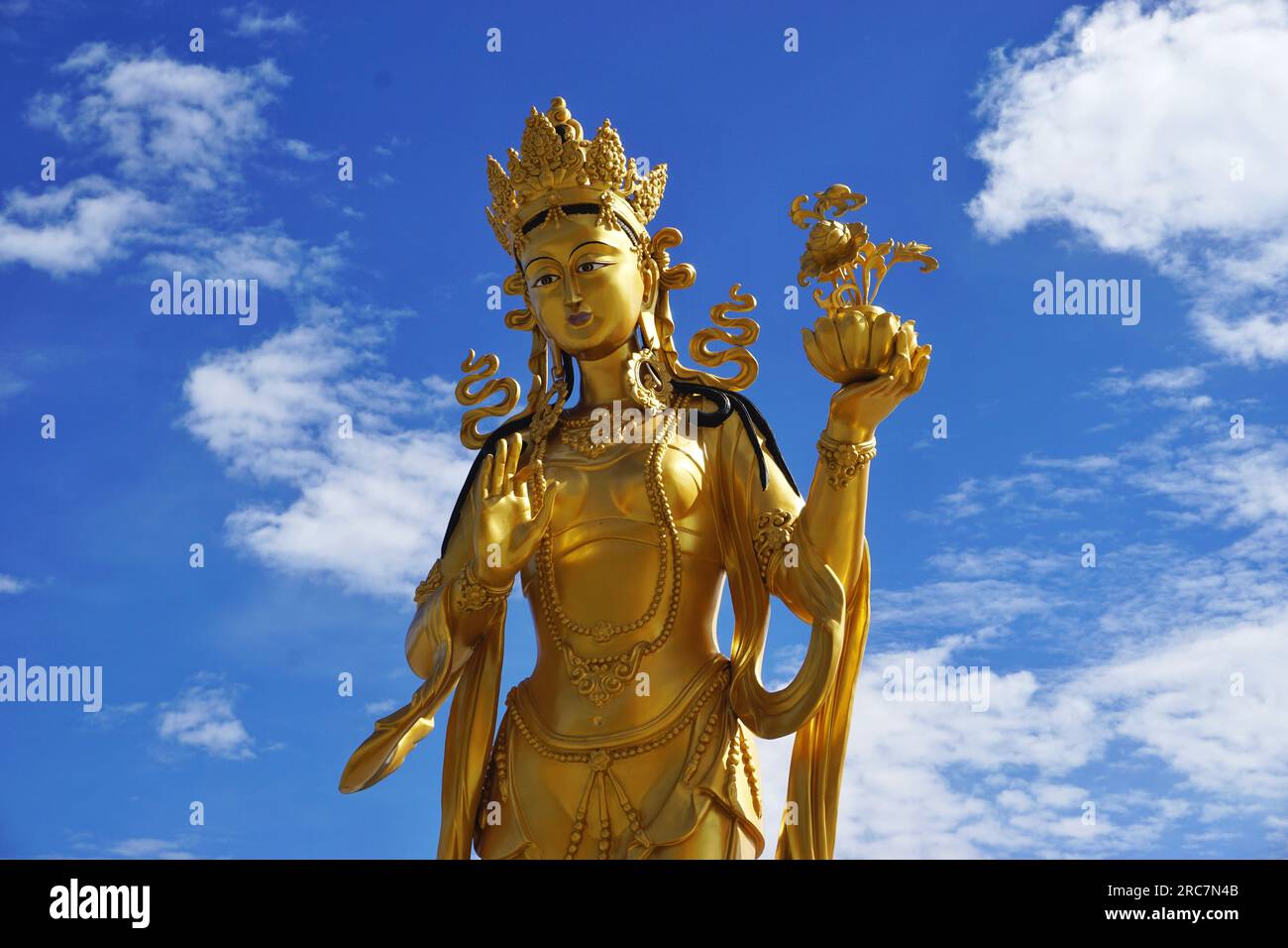 Golden goddess statue stands in silhouette against blue sky at the Buddha Dordenma monument in the Kuensel Phodrang nature park near Thimphu, Bhutan Stock Photo