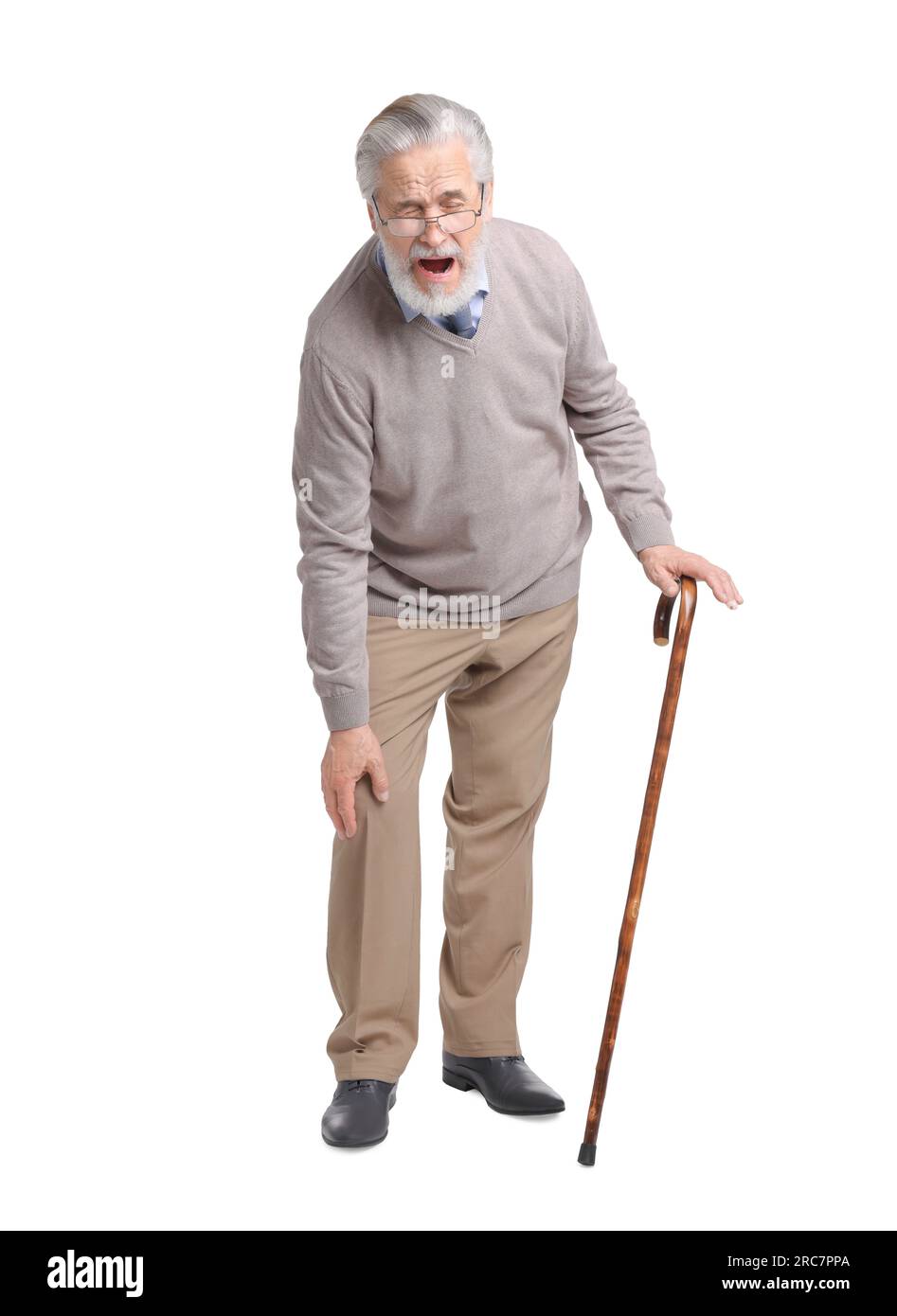 Senior man with walking cane suffering from knee pain on white
