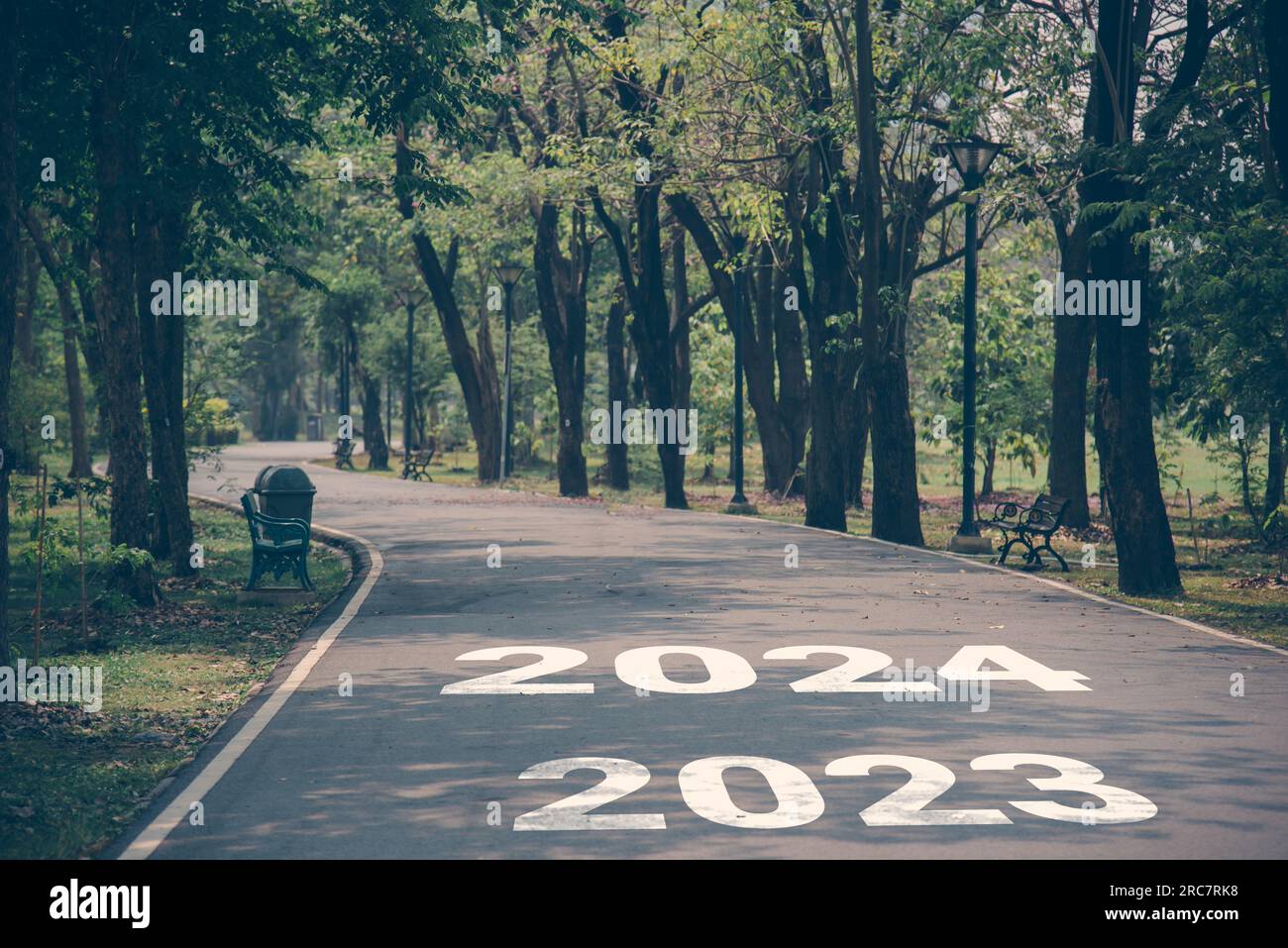 Happy New Year road trip travel celebration at the start 2023 replaced by 2024 with a park road for a successful start to a new year. Stock Photo