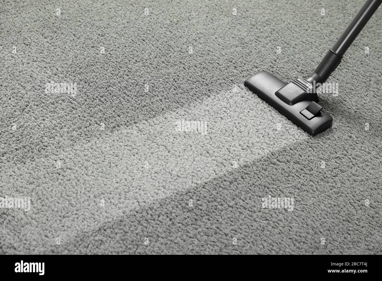 Vacuuming grey carpet. Clean area after using device. Space for text Stock Photo