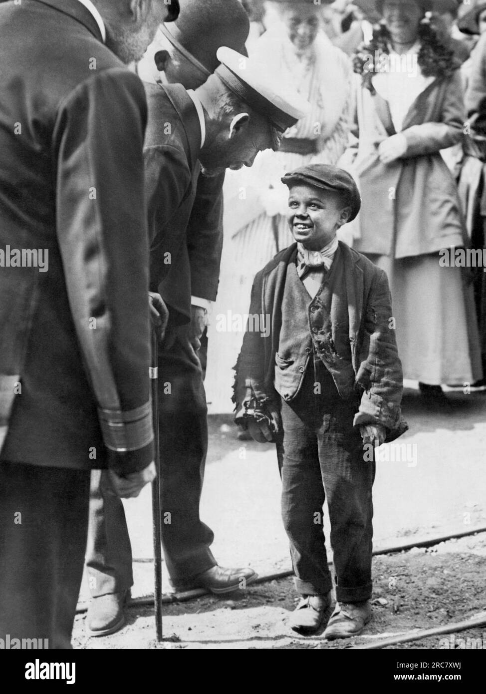 Sunderland, England: c. 1930 King George V stops to talk to a little working lad during the Royal Visit to Sir James Laing and Sons Deptford Yard. Stock Photo