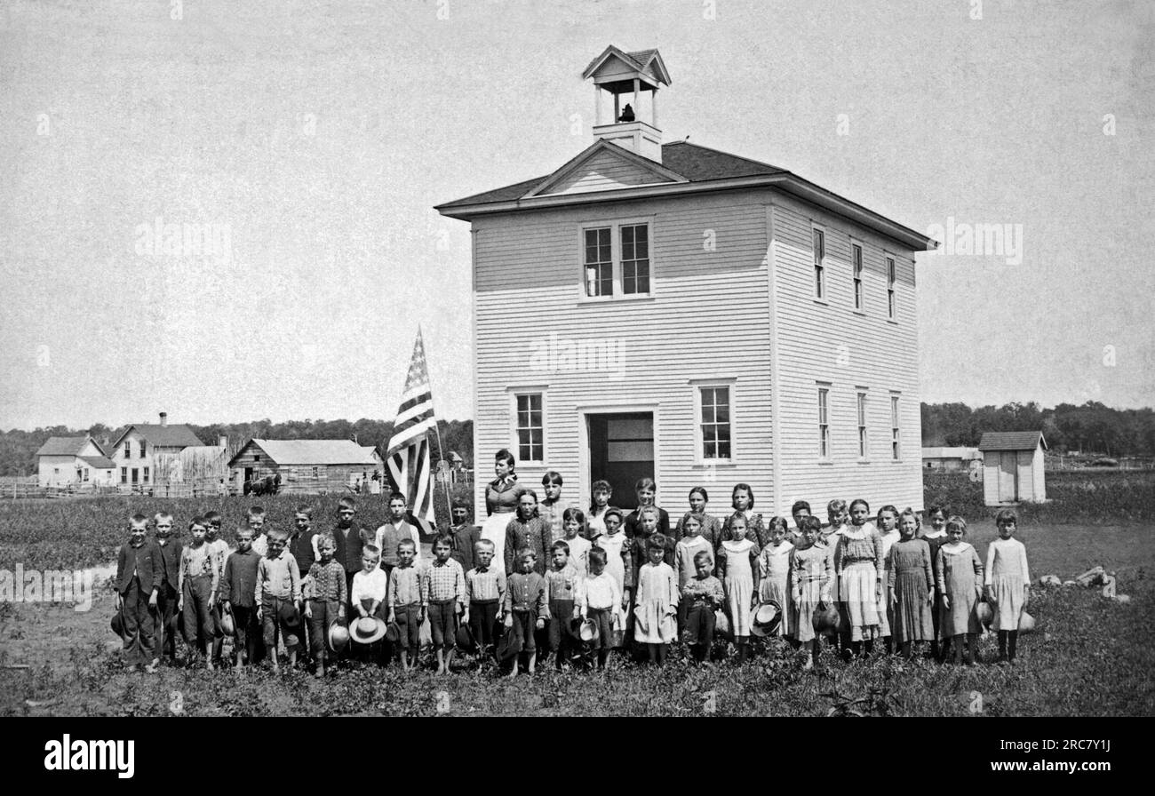 United States:  c. 1890. A one room schoolhouse in the prairie with the class and teacher out front for their portrait. Stock Photo