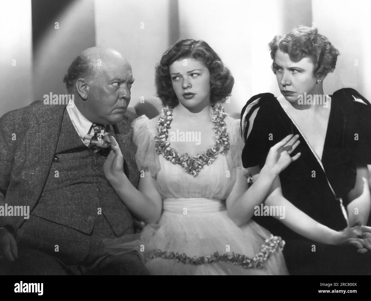 Hollywood, California:    c. 1936 A young woman tries to keep the peace between an older couple Stock Photo
