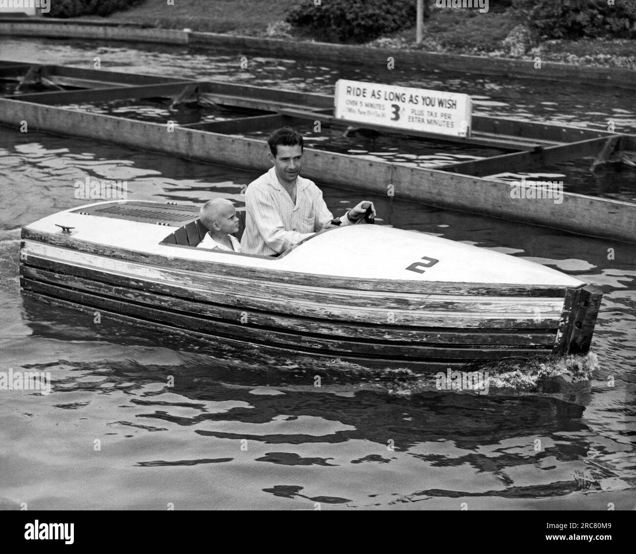San Francisco, California  c. 1955 A father and his son take a spin on a boat ride at Playland At The Beach in San Francisco. Stock Photo