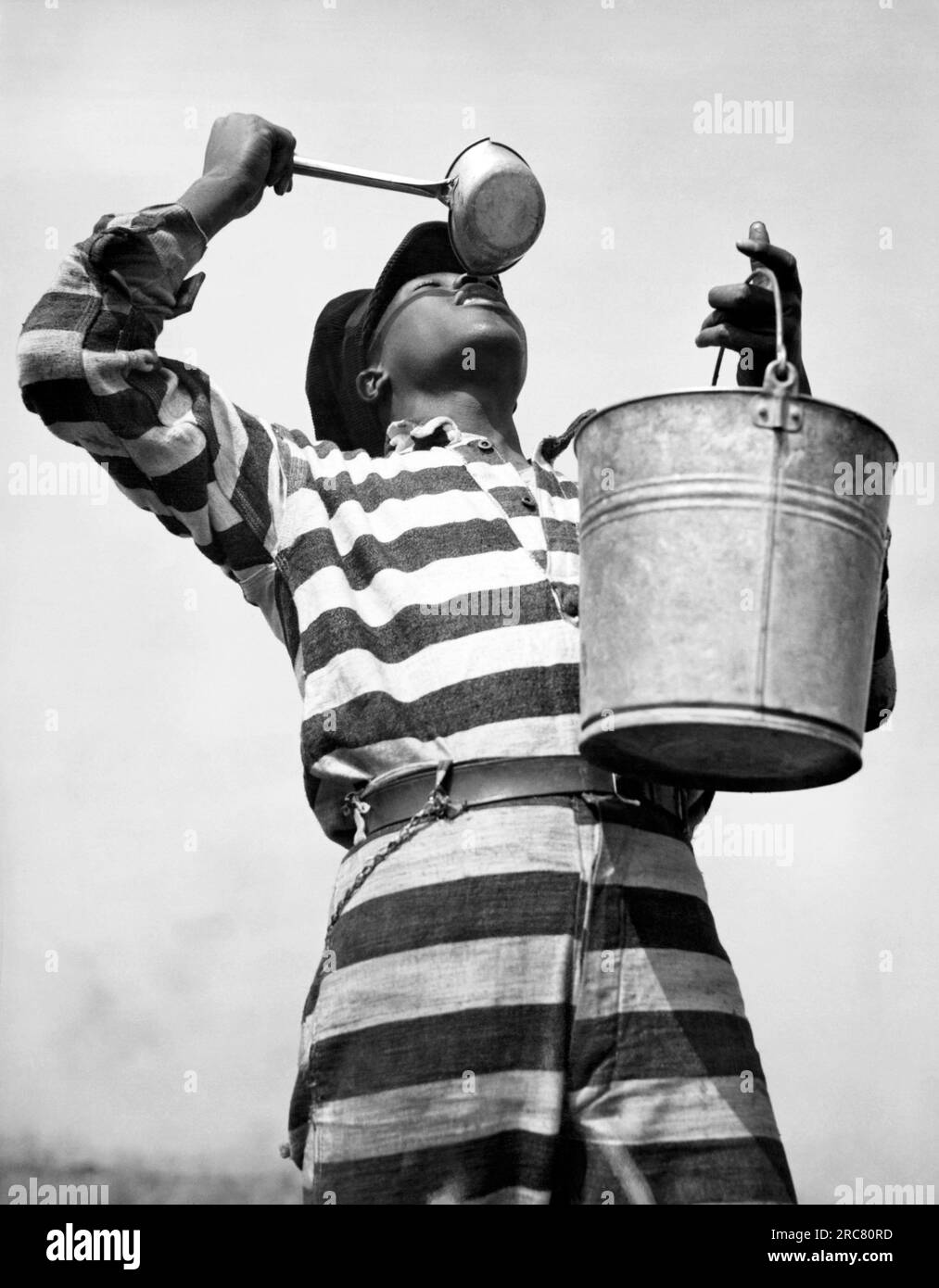 Macon, Georgia:  March 8, 1937 A prisoner working on the Bibb County chain gang quenches his thirst after hours of toil on a road. Stock Photo