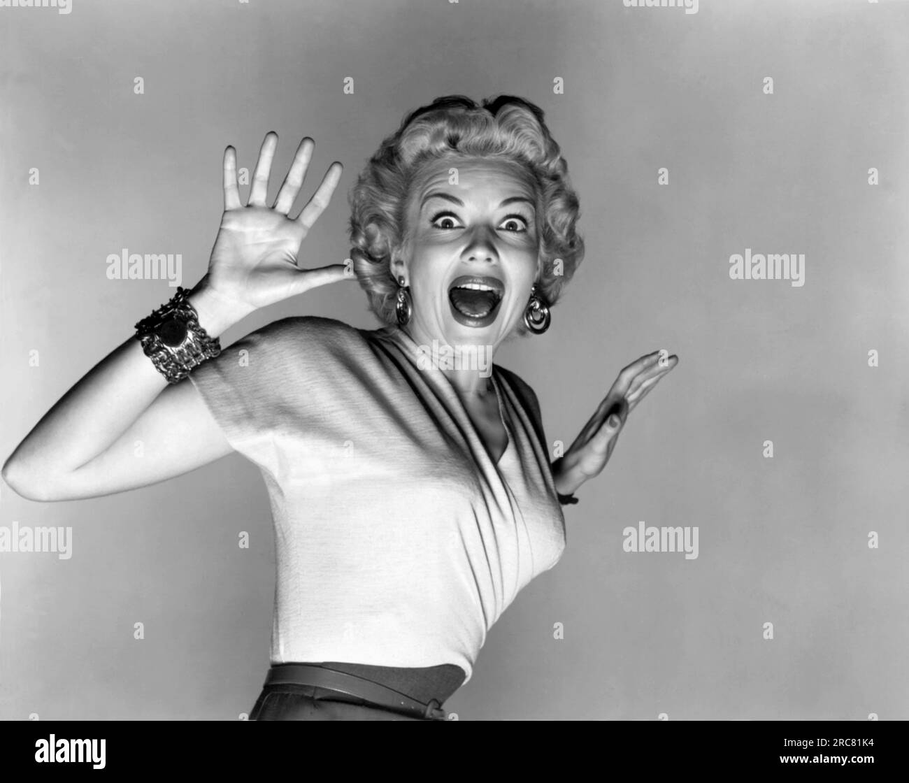 Hollywood, California:  1953.  Actress Kathleen Hughes reacts to the aliens in a promo still for the sc-fi thriller movie, 'It Came From Outer Space'. It was Universal Studio's first movie to be filmed in 3-D. Stock Photo