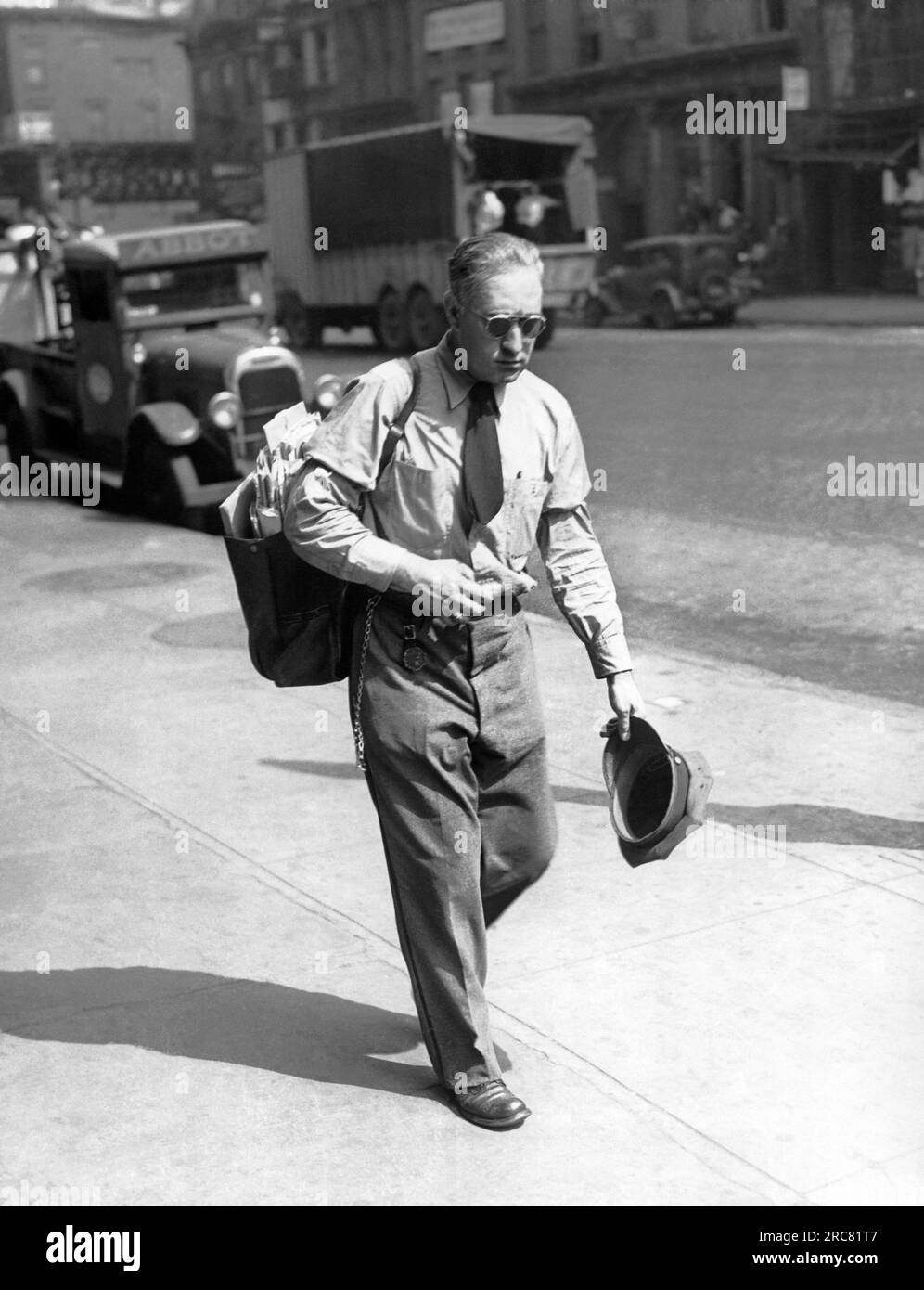 New York, New York:    c. 1937 A mailman looking very warm as he delivers mail on a hot day in the city. Stock Photo