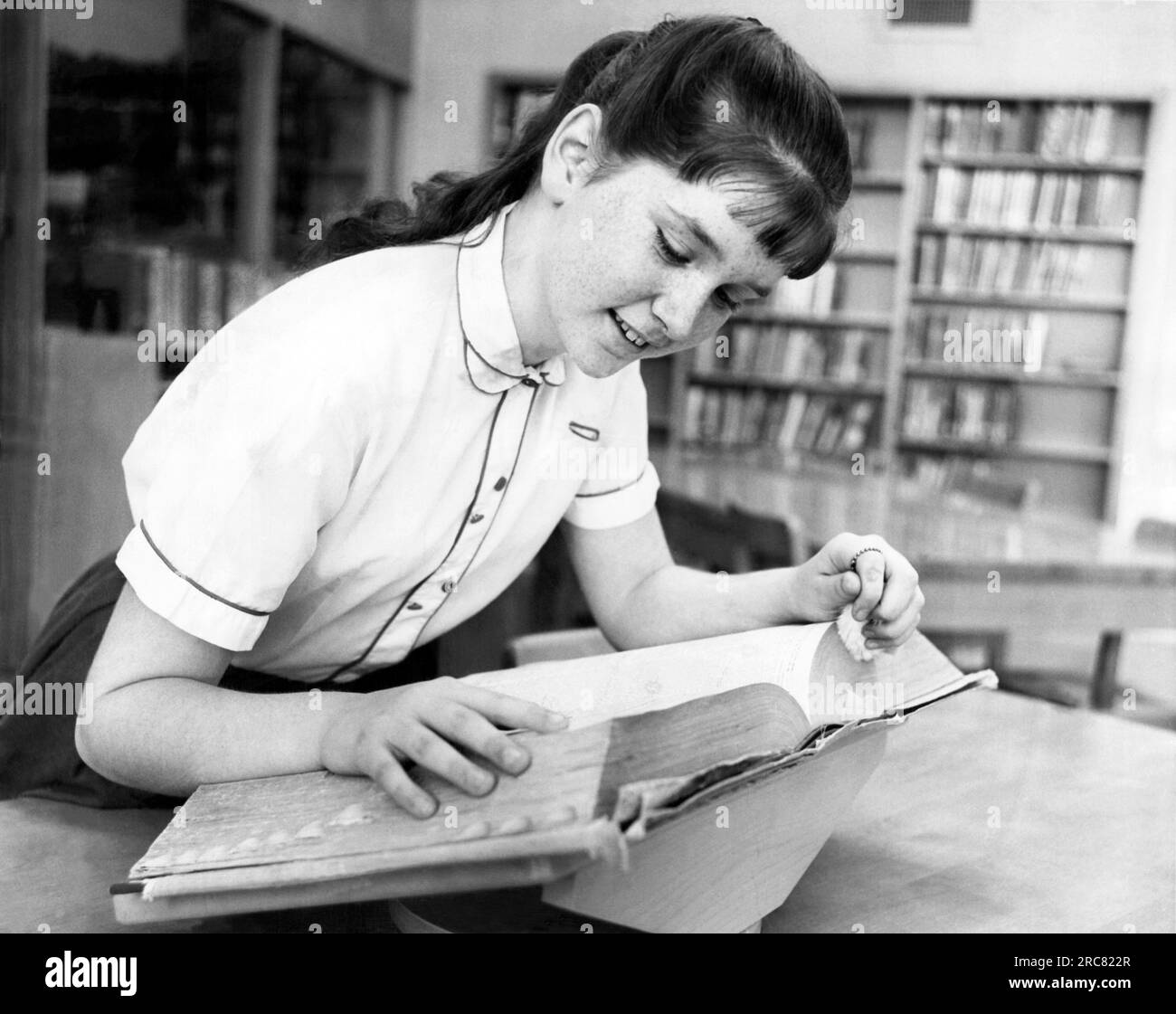 Detroit, MIchigan:  April 30, 1963 A seventh grade spelling bee champion looks up a word in the dictionary. Stock Photo