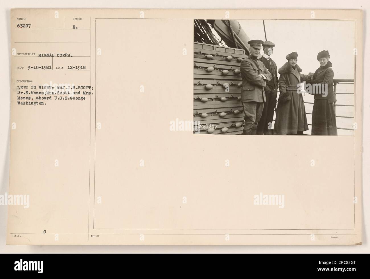 From left to right: Major J.B. Scott, Dr. S. Mezes, Mrs. Scott, and Mrs. Mezes are seen aboard the U.S.S. George Washington. This photograph was taken in December 1918 at 1800 hours. It was received by the Signal Corps on March 10, 1921 (Sumber 63207 Symbol E). Additional notes indicate the identities of the individuals captured in the image. Stock Photo