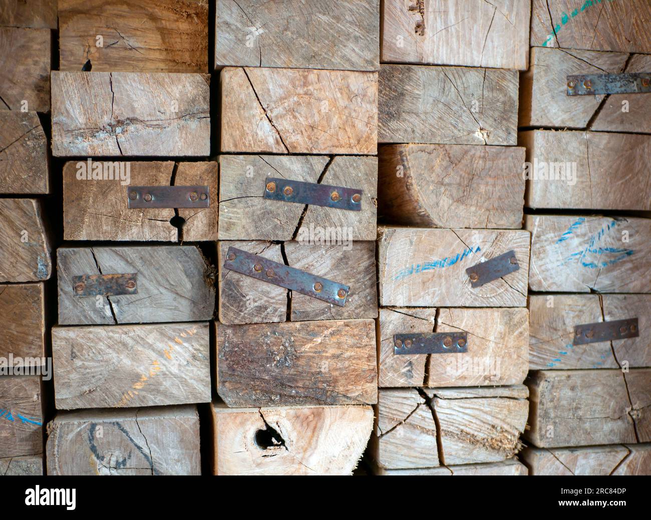 Boxshaped pile of teak wood with crack patches, made of metal plates