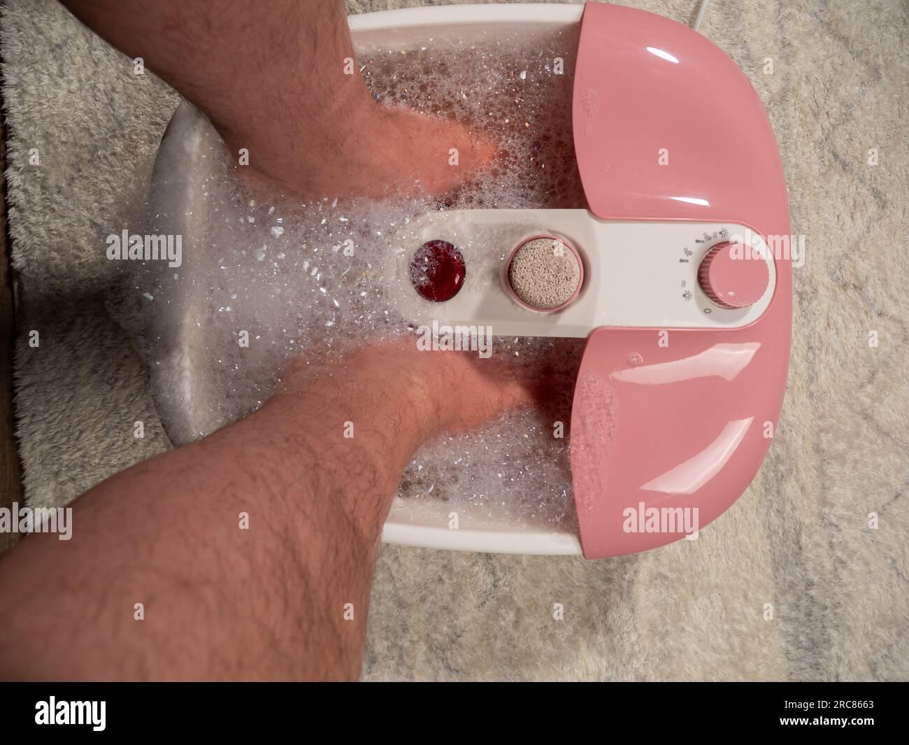 Men's legs in a vibrating foot massager. Electromassage foot bath. Relax after work. Feet care Stock Photo - Alamy Men's legs in a vibrating foot massager. Electromassage foot bath. Relax after work. Feet care Stock Photo - Alamy