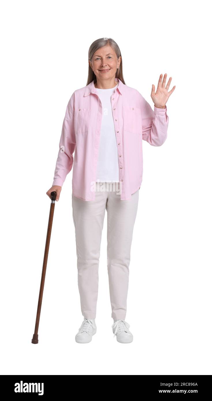 Senior woman with walking cane waving on white background Stock Photo ...