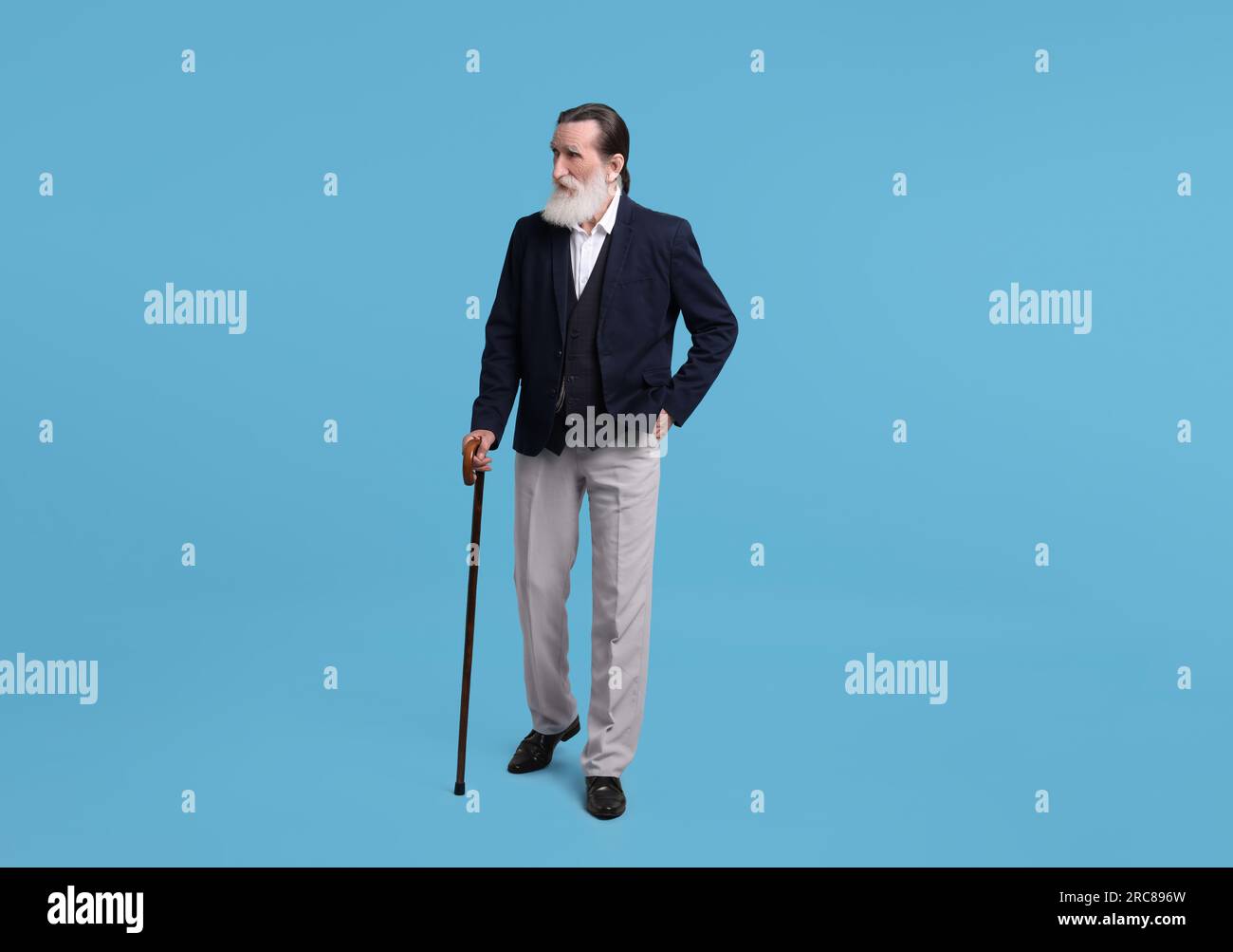 Senior man with walking cane on light blue background Stock Photo - Alamy
