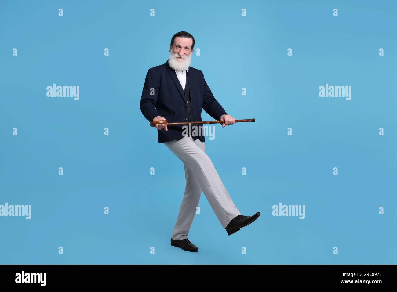 Senior man with walking cane on light blue background Stock Photo - Alamy
