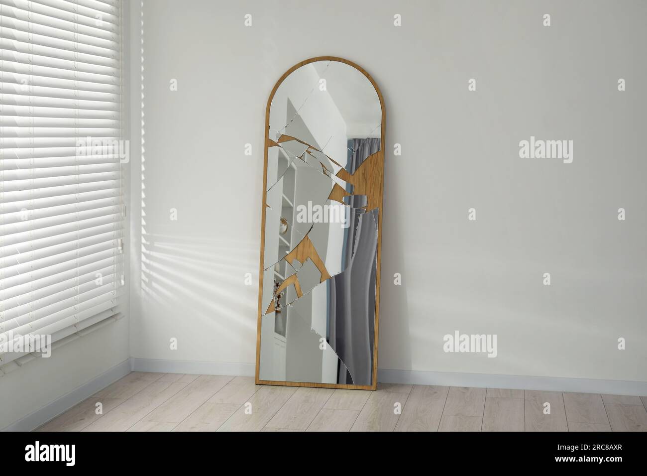 Broken mirror with many cracks near white wall indoors Stock Photo Alamy