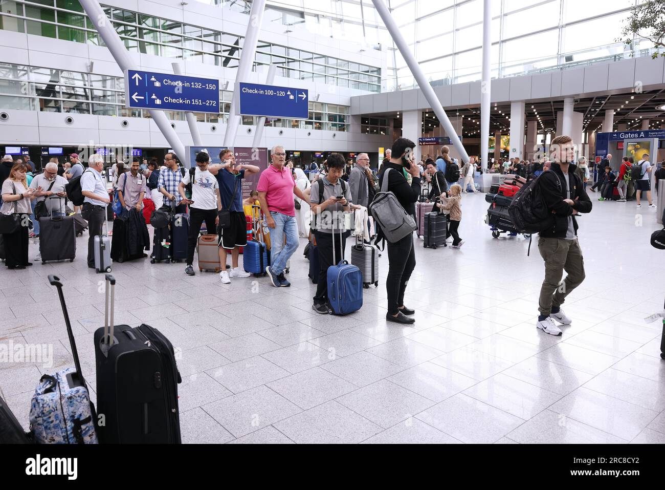Duesseldorf, Germany. 13th July, 2023. Passengers stand in queues in the terminal of DUS airport after activists from the group Letzte Generation (Last Generation) got stuck on the tarmac. Credit: David Young/dpa/Alamy Live News Stock Photo