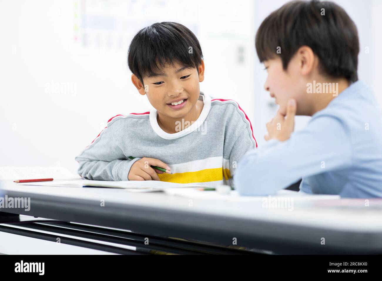 Elementary school student studying with friends Stock Photo - Alamy
