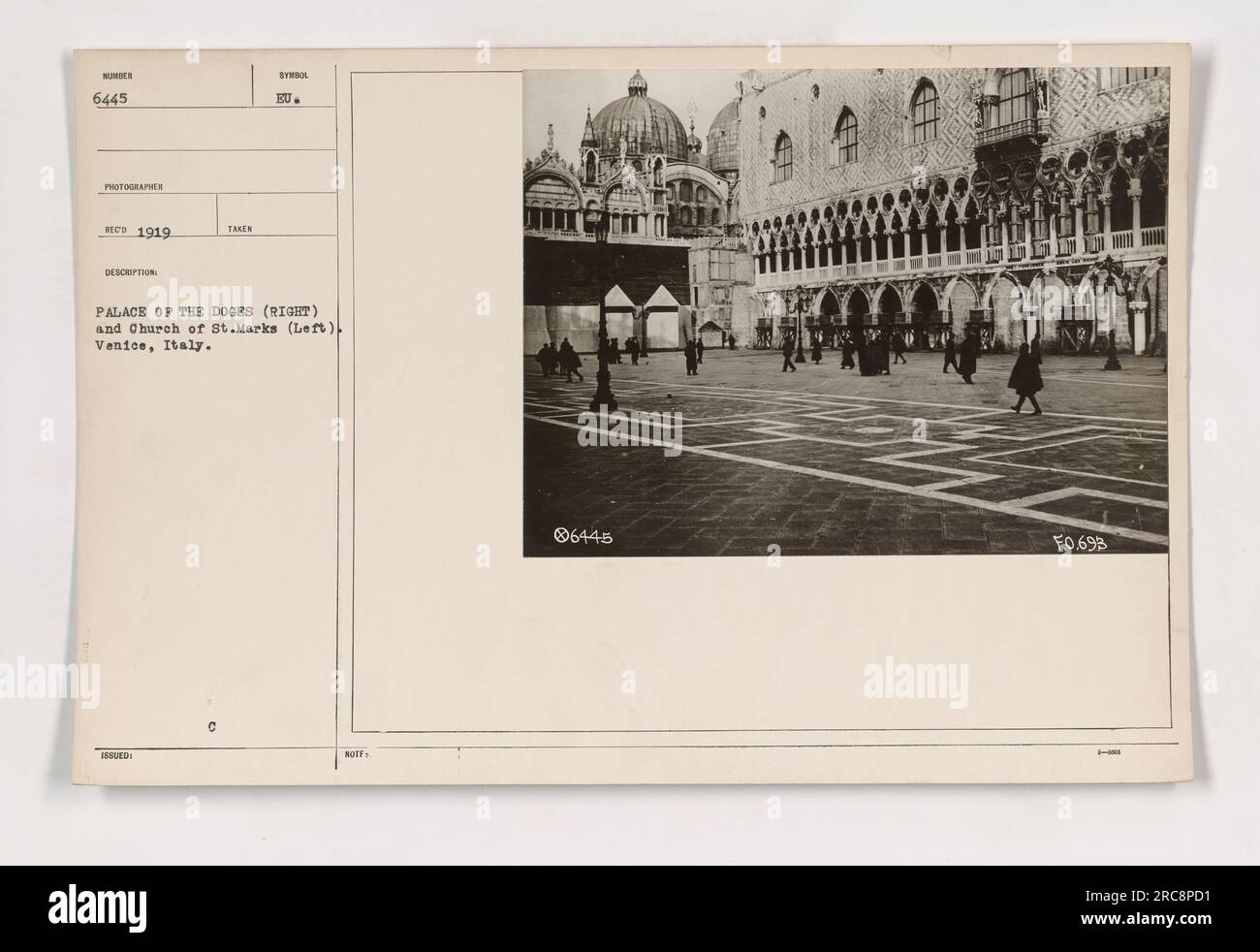 111-SC-6445: A photo taken in Venice, Italy, showing the Palace of Doges on the right and the Church of St. Marks on the left in Piazza San Marco. The photograph was taken in 1919 by a photographer with the initials 'ET.' The symbol 'KU' is also present. The photo is labeled as number 6445 and has the description 'Palace of the Doges and Church of St. Marks in Venice, Italy.' The print also has the number HOTE 06445 and the code F.0.693. Stock Photo