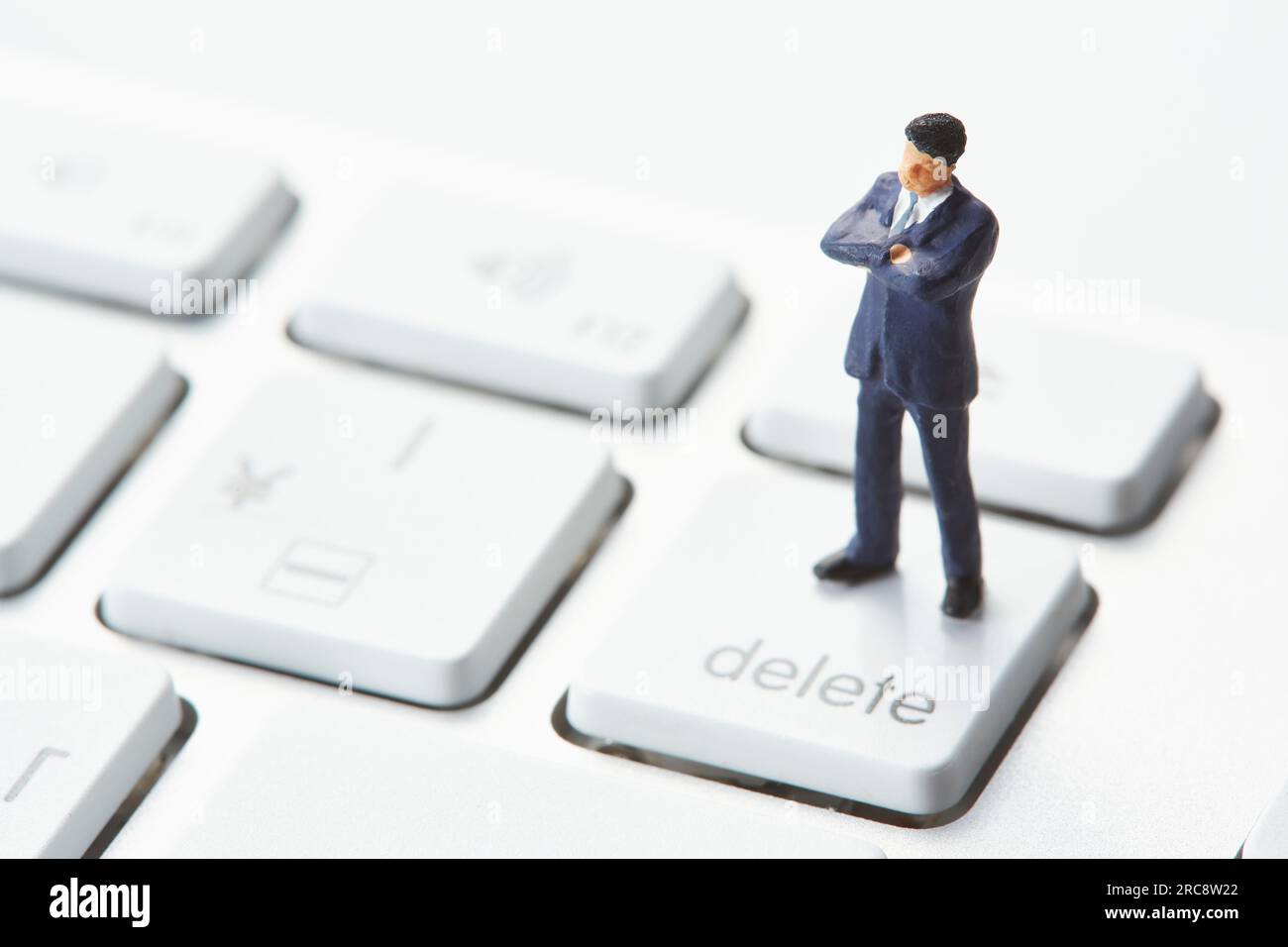 Miniature doll crossing arms on keyboard Stock Photo