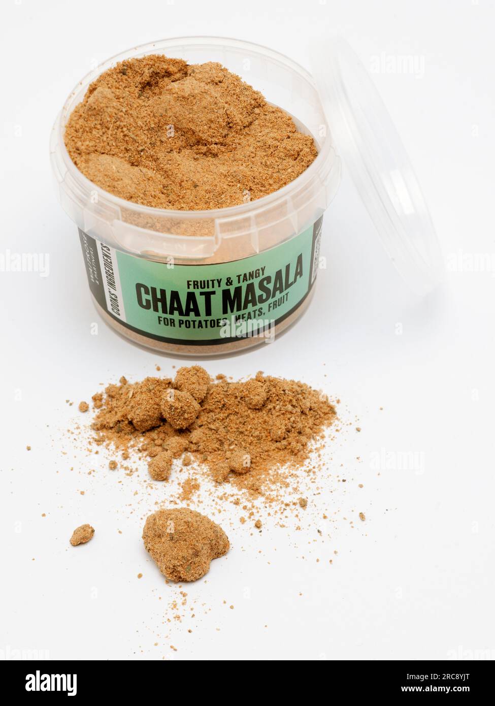 56g Open Container with Lid and a pile of Cooks' Ingredients Chaat Masala on a White Background Stock Photo