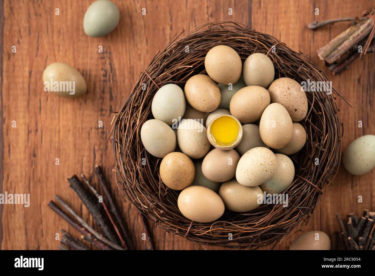 Top view of fresh button quail eggs in a nest on wooden table background. Stock Photo