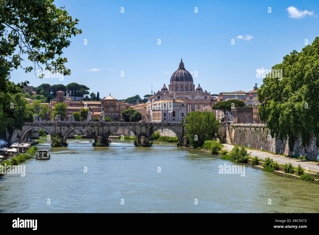 View along River Tiber to Ponte Sant' Angelo, with dome of St. Peter's Basilica in background, in Rome, Lazio Region, Italy Stock Photo