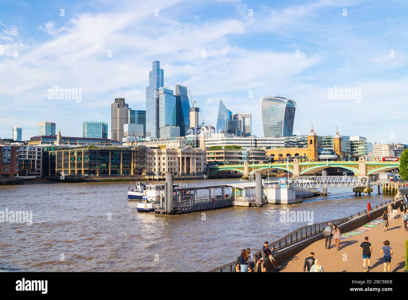 LONDON, UK - 6TH JULY 2023: Bankside and City of London skyline during the day. People can be seen on the path. Stock Photo