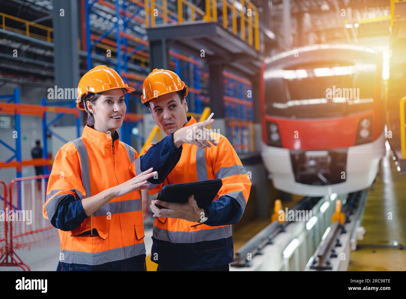 Engineer man and women worker working team together in electric train service depot transport industry factory technician mechanic staff. Stock Photo