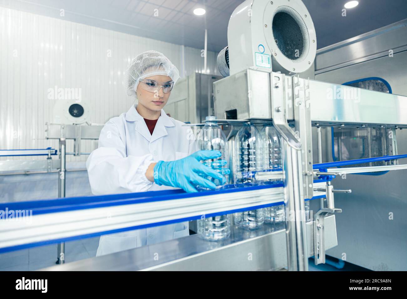 worker in drinking water factory. women workers caucasian labor in beverage clean production conveyor belt mineral water manufactory. Stock Photo