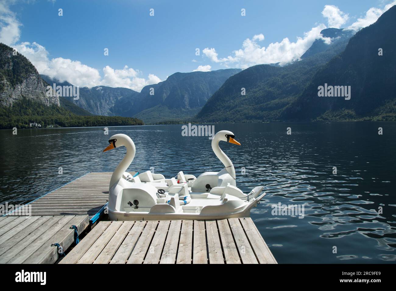 Zwei Tretboote in Form von weissen Schwaenen am Steg auf dem Hallstaetter See im Salzkammergut Stock Photo