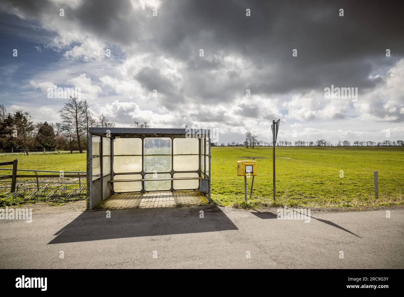 Verlassene Bushaltestelle samt Briefkasten in menschenleerer, weiter Marsch-Landschaft im Kreis Steinburg (Schleswig-Holstein) Stock Photo