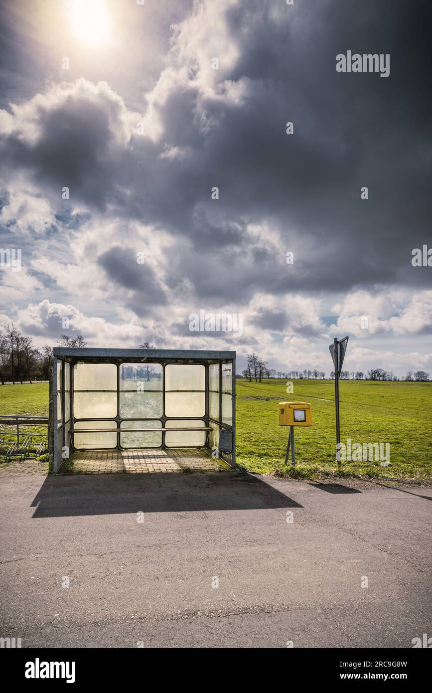 Verlassene Bushaltestelle samt Briefkasten in menschenleerer, weiter Marsch-Landschaft im Kreis Steinburg (Schleswig-Holstein) Stock Photo