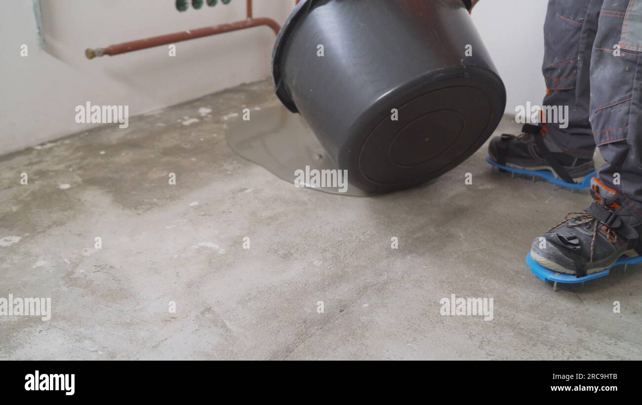 Liquid floor for leveling the base. A worker uses epoxy concrete screed to level. Leveling with