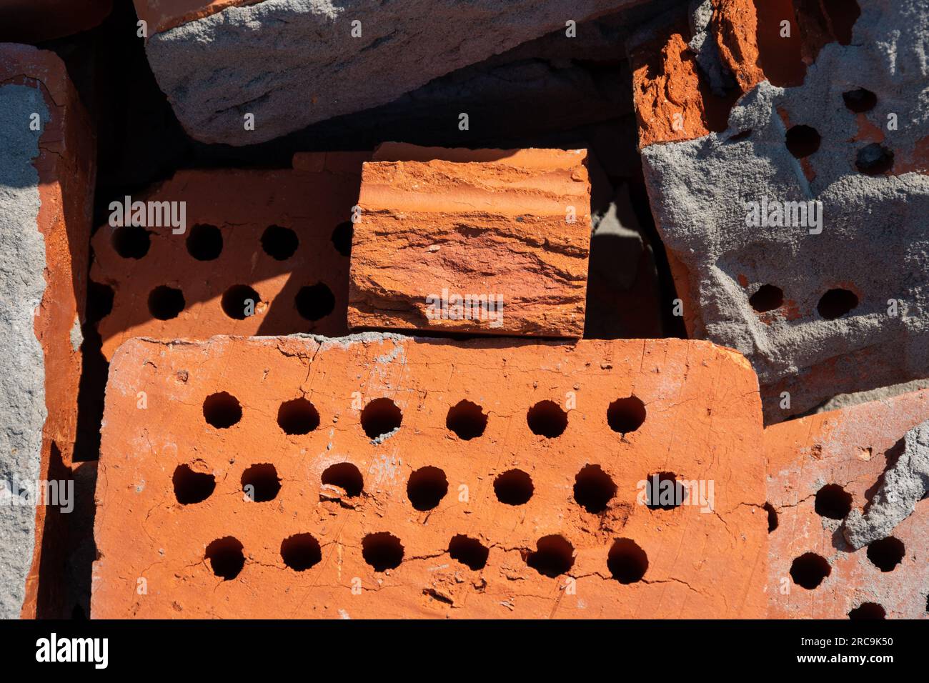 A pile of old red bricks with the remains of dried mortar. Building