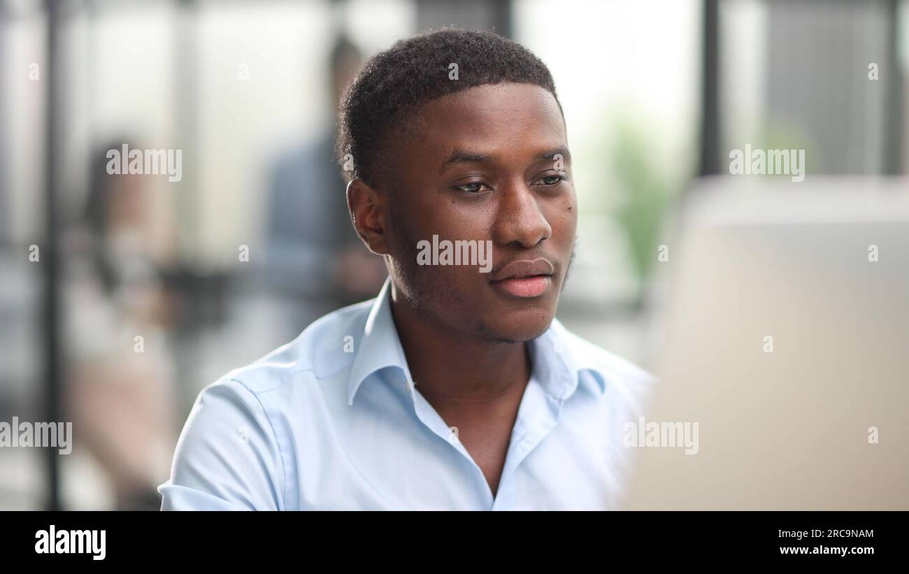 Thoughtful black man in eyeglasses stack with hard task, looking at computer screen, thinking of problem solution Stock Photo