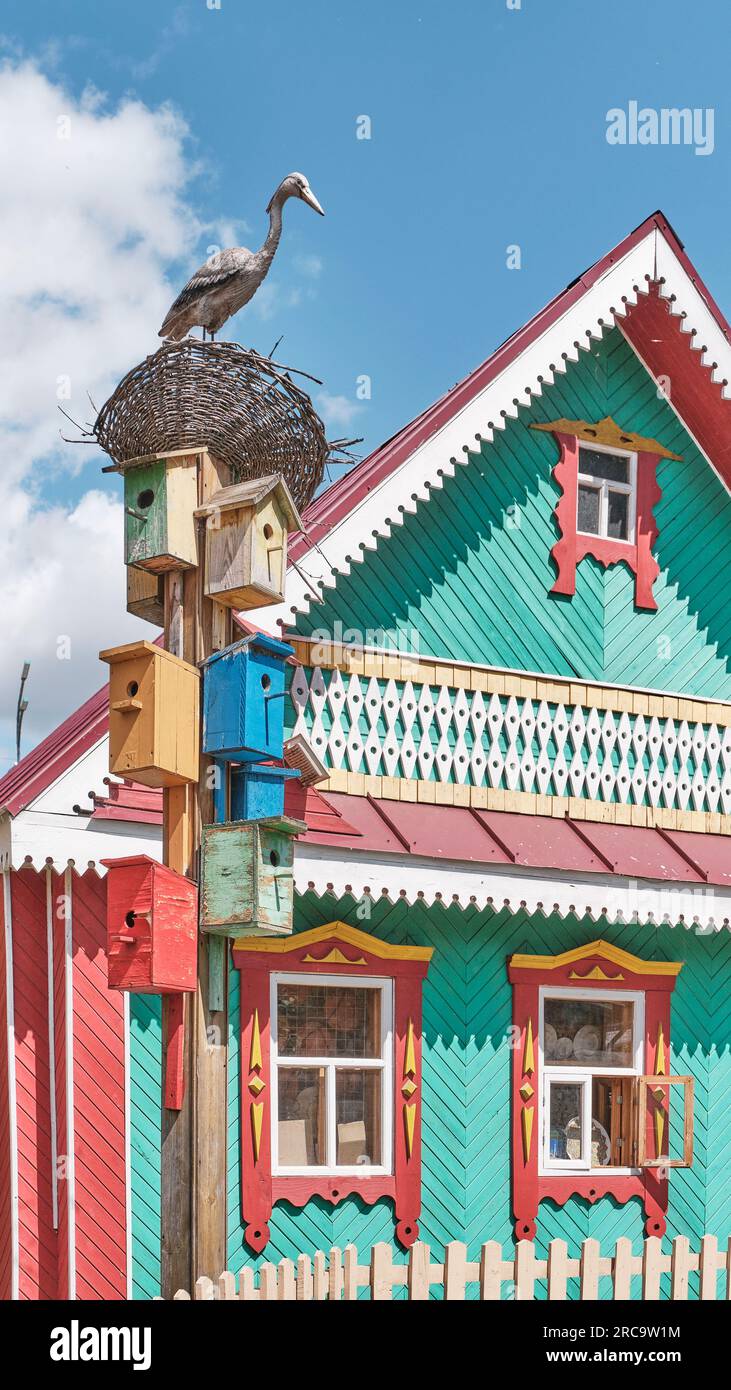 Decorative bird houses and sculpture of stork in nest on background of