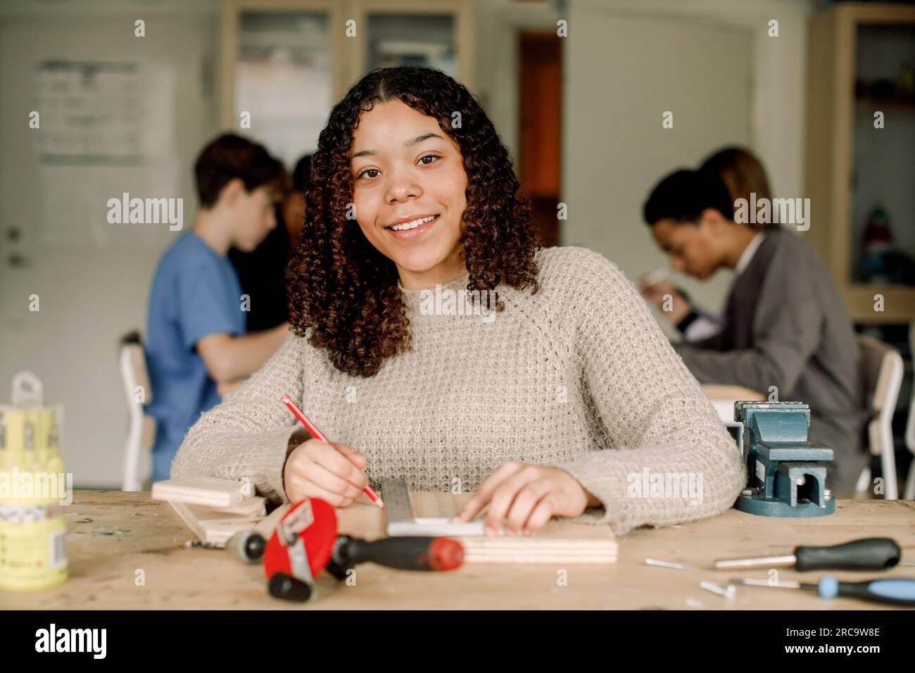 Portrait of smiling female teenage student during carpentry class at