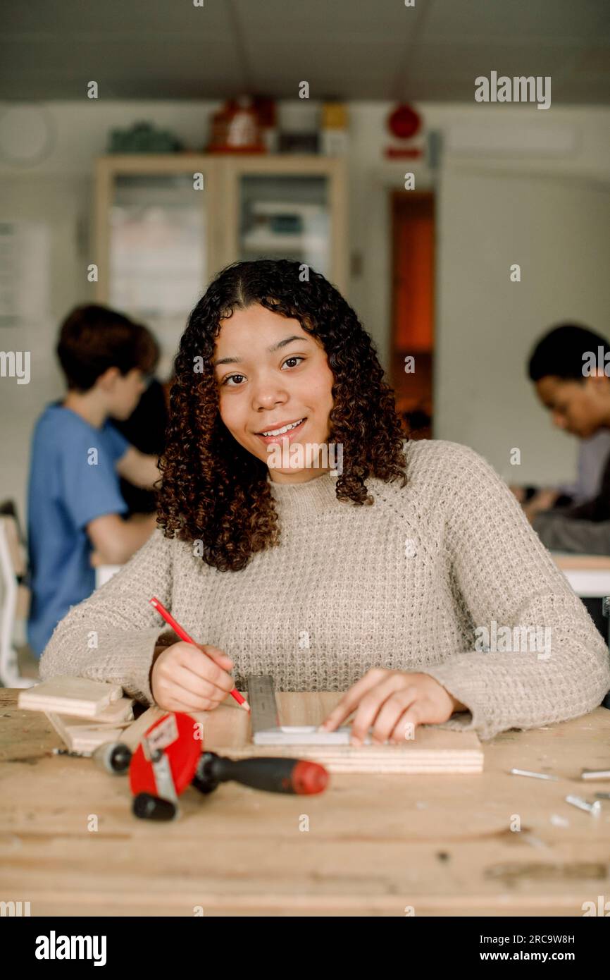 Portrait of female teenage student with ruler and pencil during