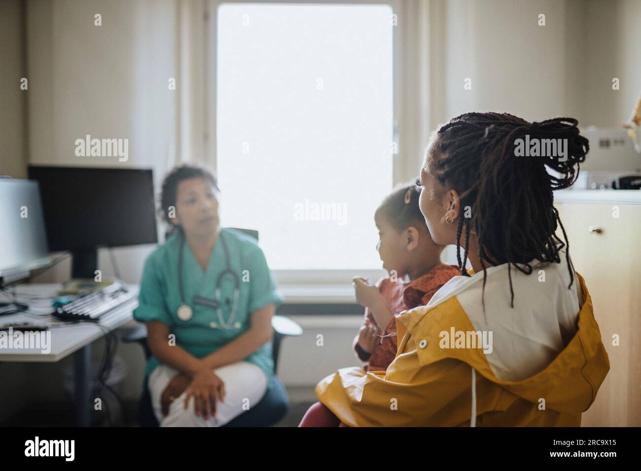 Woman with daughter visiting female pediatric in clinic Stock Photo