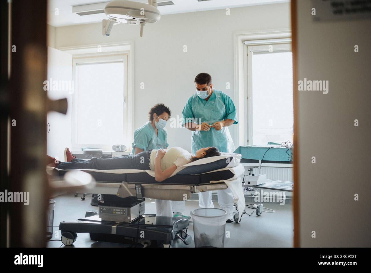 Male And Female Surgeons Examining Patient On Bed In Hospital Stock Photo Alamy