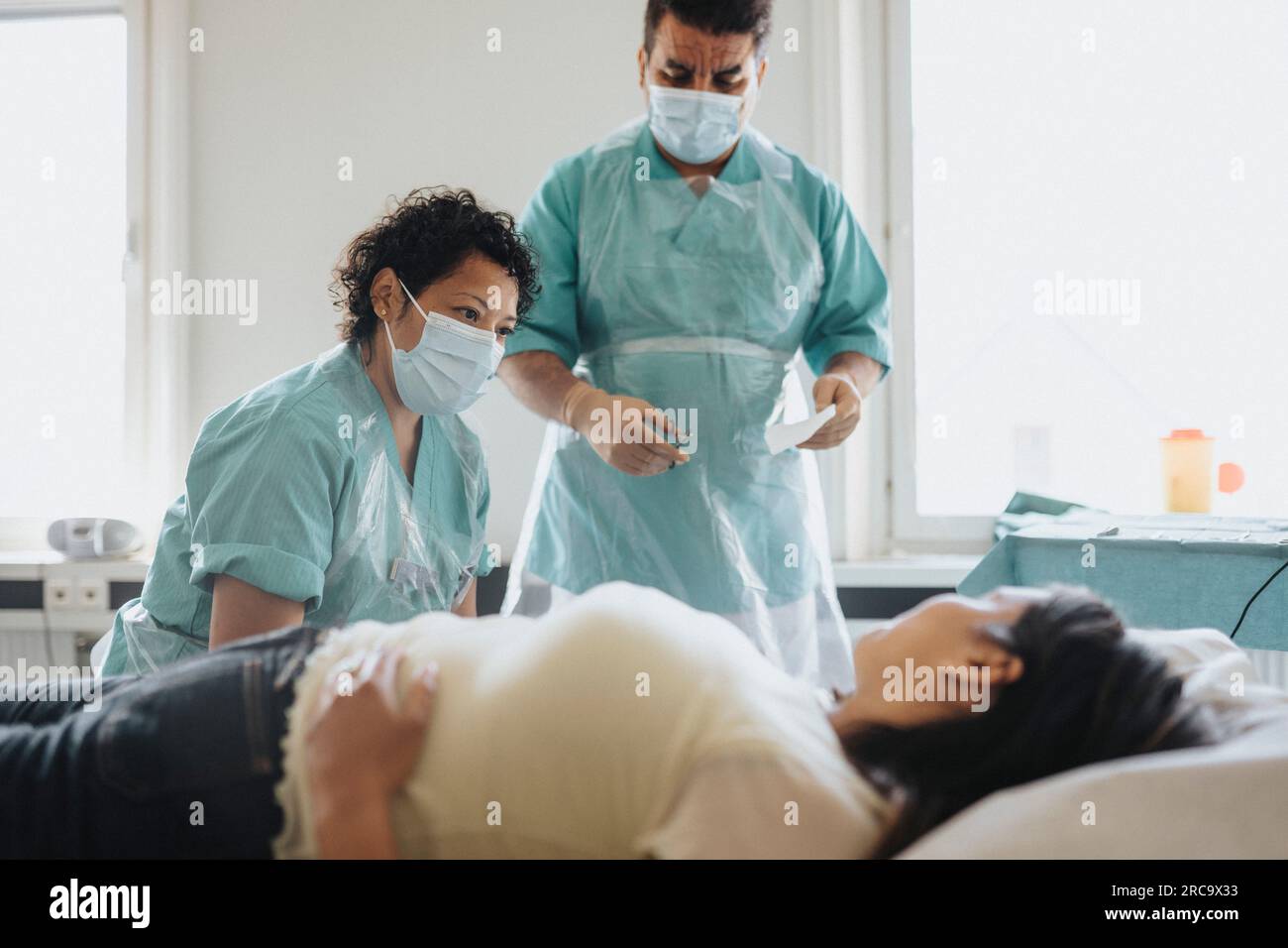 Male and female doctors examining patient in hospital Stock Photo